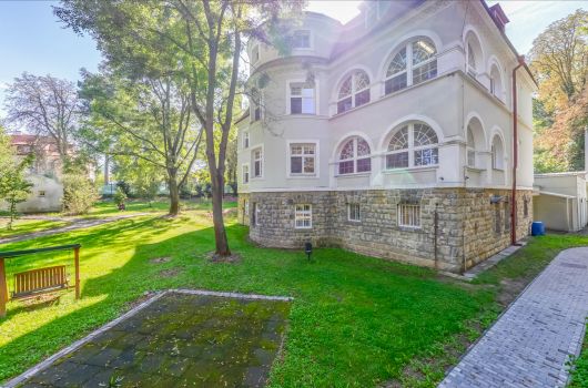 Domov a jeho zahrada s lavečkou za slunečného dne